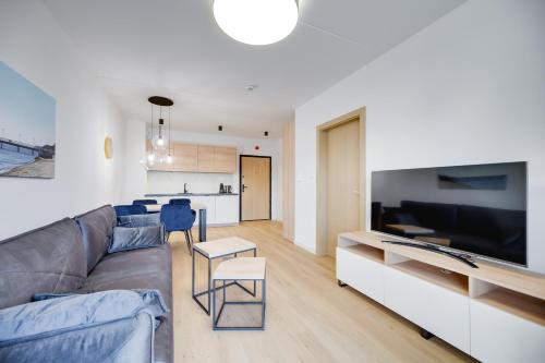 a living room with a couch and a tv at ReVital Mechelinki by Homeprime Parking Free in Mechelinki
