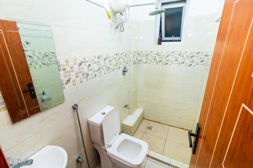 un baño con inodoro y ducha en Visitors homes, en Mombasa