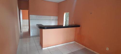 a room with an orange wall with a counter in it at Casa para temporada COP 30 in Belém