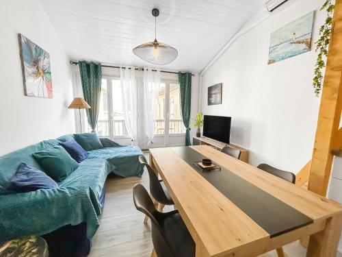 a living room with a couch and a table at Maison charmante clim et balcon en centre ville in Marseillan