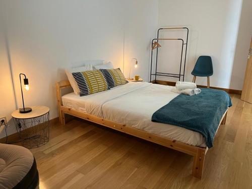 a bedroom with a bed with a blue blanket and two lamps at Ramona in Aveiro
