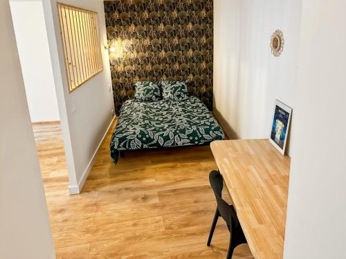 une petite chambre avec un lit et une table dans l'établissement Studio Atypique Centre Vichy, à Vichy
