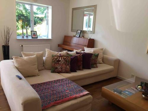 a living room with a couch and a piano at Dream house with lake view, 20 min near Copenhagen in Virum