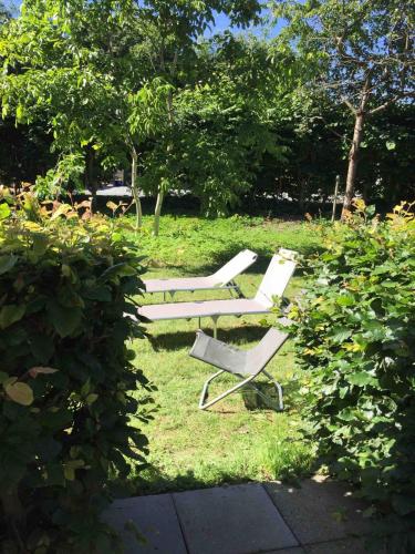two white lounge chairs sitting in the grass at Dream house with lake view, 20 min near Copenhagen in Virum