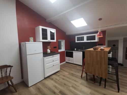 - une cuisine avec des appareils électroménagers blancs et une table dans l'établissement Etape magique a l'Escale, à Guilherand