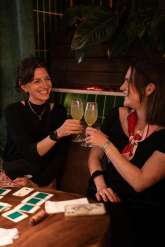 two women sitting at a table with glasses of wine at Rango Hostel Boutique in Medellín