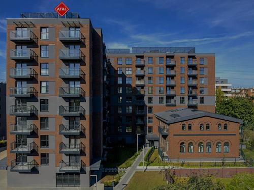 a tall apartment building next to a building at Wolne Pokoje I Boutique Apartments in Wrocław