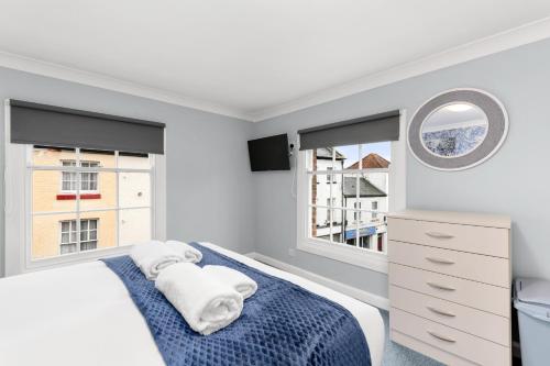 a white bedroom with a bed and a mirror at Town House Rooms in Boston
