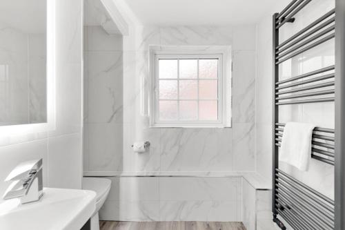 a white bathroom with a sink and a window at Town House Rooms in Boston
