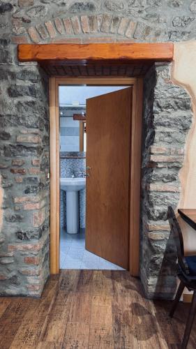 a bathroom with a door in a stone wall at B&B Al Vecchio Molino in Valbrembo