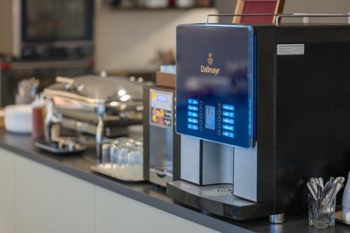 a counter with a microwave on top of a counter at Baross City Hotel - Budapest in Budapest