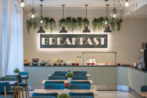 a restaurant with blue chairs and a sign that reads breakfast at Baross City Hotel - Budapest in Budapest