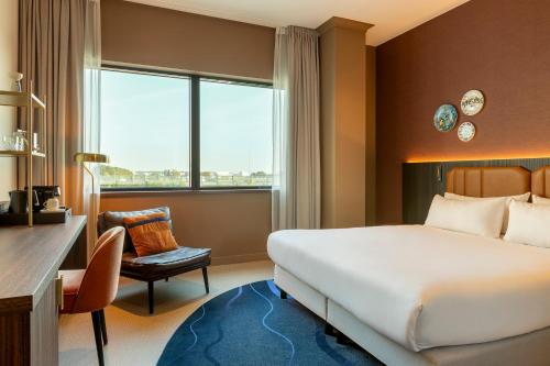バドフーフェドルプにあるCorendon Amsterdam Schiphol Airport, a Tribute Portfolio Hotelのベッドと机があるホテルの部屋