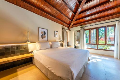 a bedroom with a large bed and a large window at Hotel Huerto del Cura in Elche