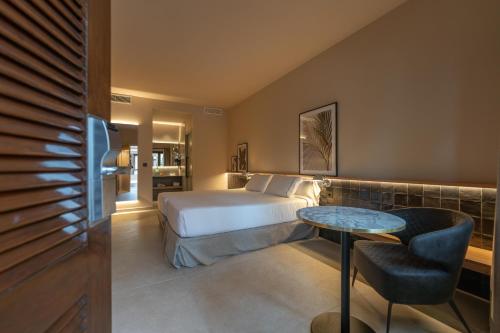 a hotel room with a bed and a table at Hotel Huerto del Cura in Elche