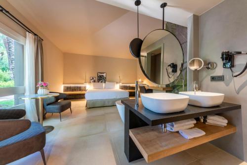 a bathroom with two sinks and a large mirror at Hotel Huerto del Cura in Elche