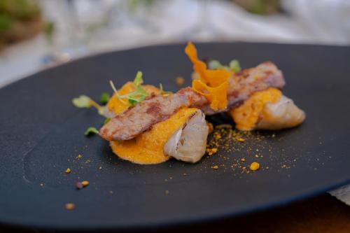 a black plate with food on a table at Hotel Huerto del Cura in Elche