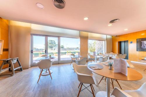 a restaurant with tables and chairs and a large window at Port Azafata Valencia in Manises