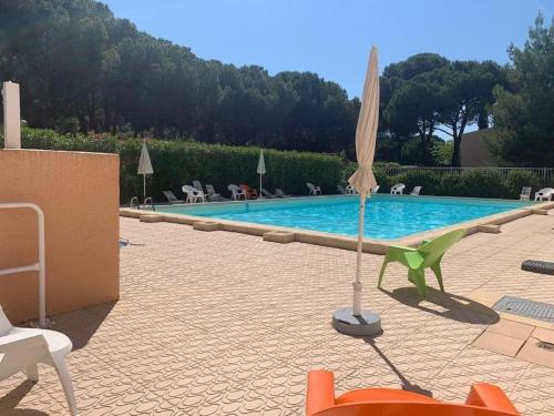 un parasol assis à côté d'une piscine dans l'établissement 007 Ipanema i313, au Cap d'Agde