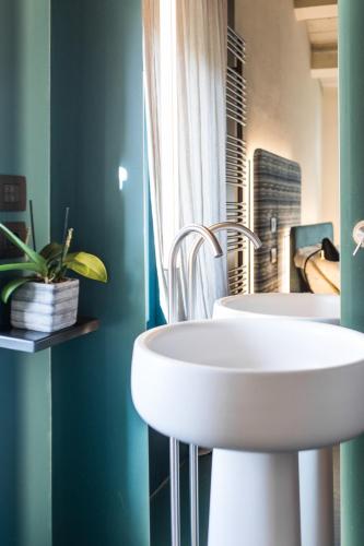 two white sinks in a bathroom with green walls at Cà Toresele Relais Osteria Garden in Verona