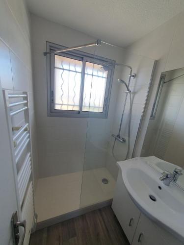 une salle de bain avec une douche et un lavabo et une fenêtre dans l'établissement Appartement avec vue sur la mer - A04110, à Soulac-sur-Mer