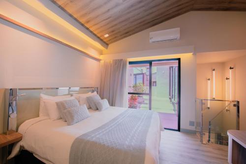 a bedroom with a large white bed and a window at Mercure Curitiba Batel in Curitiba