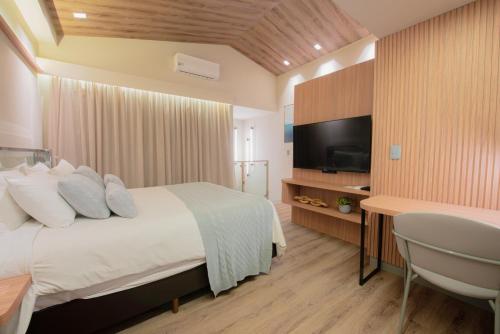 a bedroom with a bed and a flat screen tv at Mercure Curitiba Batel in Curitiba