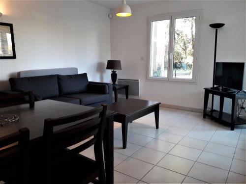 un soggiorno con un divano e un tavolo di Studio dans une résidence calme - 9544 a Soulac-sur-Mer