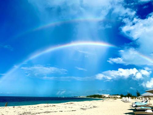 a rainbow in the sky over a beach at Flamingo House - Turks & Caicos in Turtle Cove