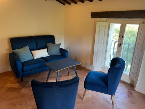 a living room with a blue couch and chairs at La Melagrana in Brisighella