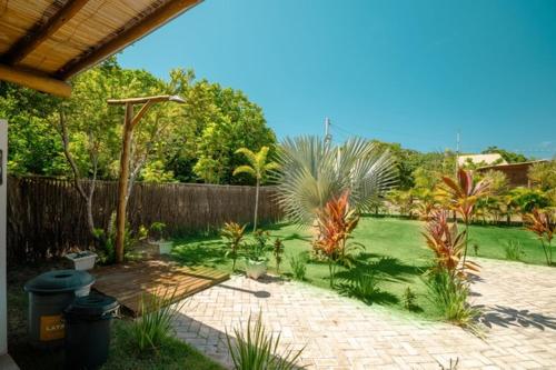 a backyard with a garden with plants and a fence at Bons Ventos Camping e Glamping in Barra Grande