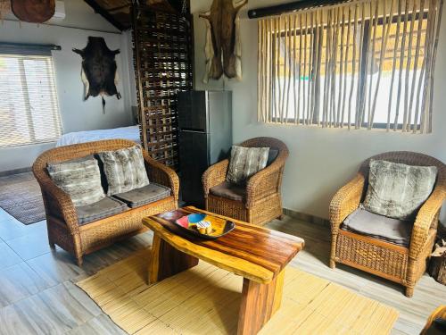 a living room with wicker chairs and a coffee table at kwamapulaneng guest house in Matrooster