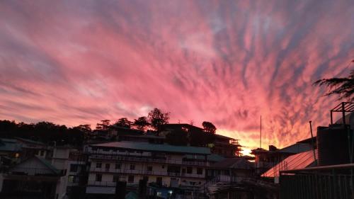 a sunset with a red sky with clouds at Verma Guest House in Dharmsala