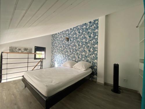 une chambre avec un lit avec un mur bleu et blanc dans l'établissement Appartement duplex - 2701, à Soulac-sur-Mer