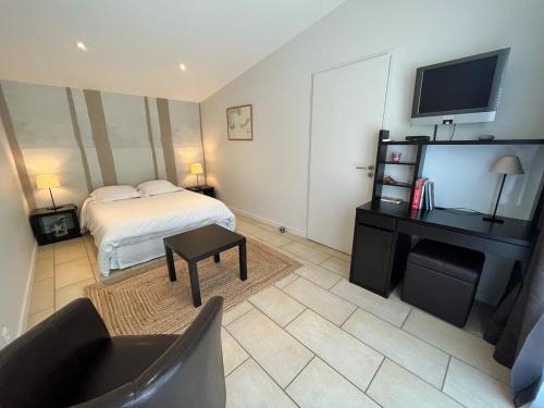 une chambre avec un lit, un bureau et une télévision dans l'établissement Havre de paix à deux pas de la Croix-Rousse, à Caluire-et-Cuire