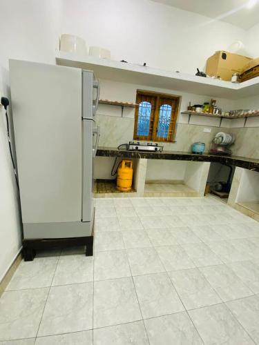 a kitchen with a white refrigerator in a room at Arugambay Mailakska Green Villa in Arugam Bay