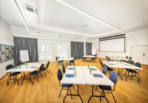 a classroom with tables and chairs and a projection screen at lyf Schönbrunn Vienna in Vienna