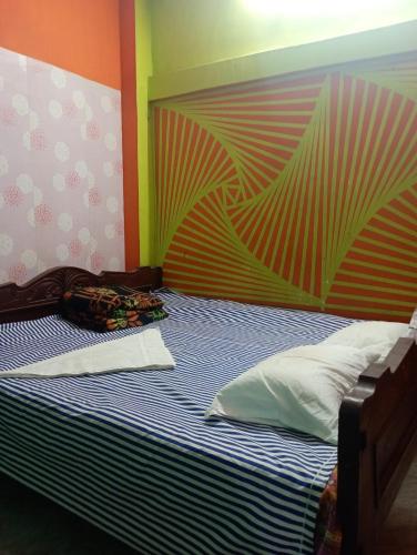 a bedroom with a bed with a colorful wall at India Tours Only Nona Mati in Gosāba