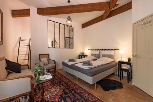 une chambre avec un lit, un canapé et une chaise dans l'établissement Maison du Lavoir Vert, à Tourbes