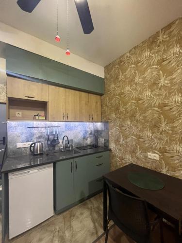 eine Küche mit einem Waschbecken und einem Tisch darin in der Unterkunft Studio apartment in Bakuriani in Bakuriani