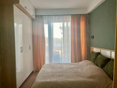 ein Schlafzimmer mit einem Bett und einem großen Fenster in der Unterkunft Studio apartment in Bakuriani in Bakuriani