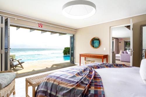 a bedroom with a bed and a view of the ocean at Villa Misty Cliffs in Scarborough