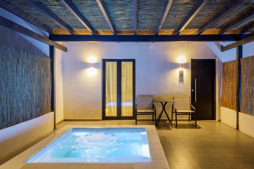 a hot tub in a room with a table and chairs at Blé Suites Santorini in Imerovigli
