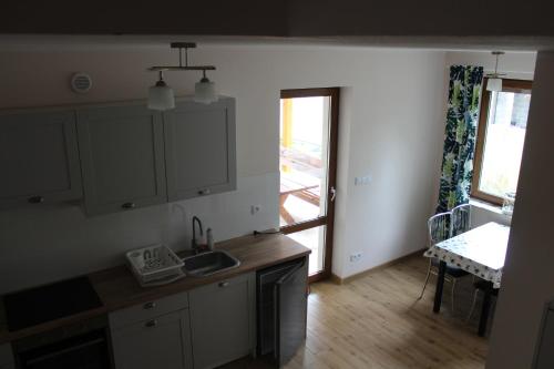 a kitchen with a sink and a table and a window at Kwatera agroturystyczna Przywóz in Przywóz
