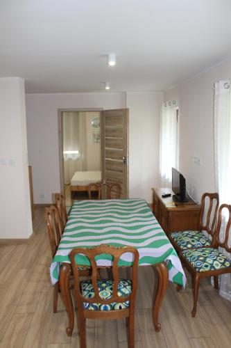 a dining room with a table and chairs and a desk at Kwatera agroturystyczna Przywóz in Przywóz