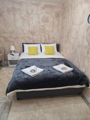 a bedroom with a large bed with towels on it at Apartman Helena 2 in Lazarevac