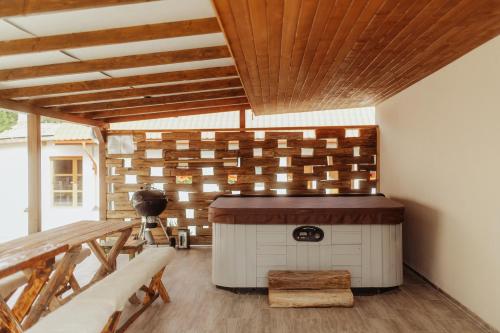 a hot tub in a room with a wooden ceiling at Natura vendégház in Abaújvár