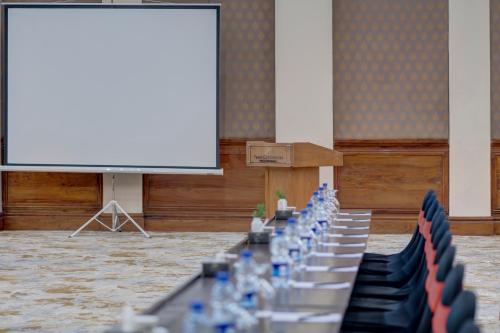 a row of tables and chairs in front of a screen at Pearl Continental Hotel, Muzaffarabad in Muzaffarabad