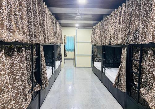 a room with two bunk beds with curtains at Jai Shree Shyam Dormitory in Mumbai