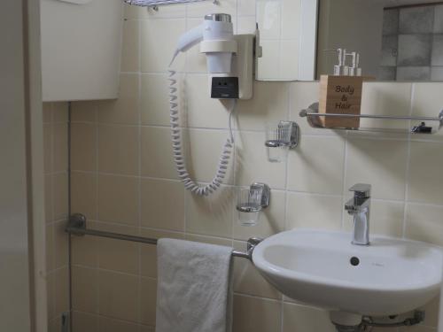 a bathroom with a sink and a phone on the wall at Botel Sailing Home in Amsterdam